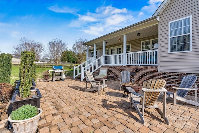 view of patio featuring area for grilling, covered porch, and fence