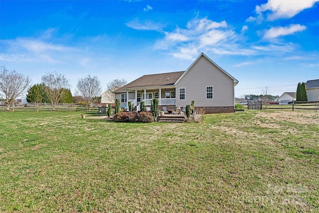 rear view of house with crawl space, a porch, a yard, and fence