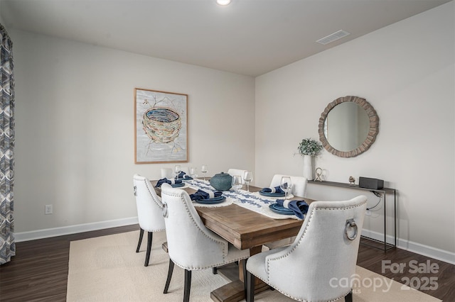 dining room with baseboards, visible vents, and wood finished floors