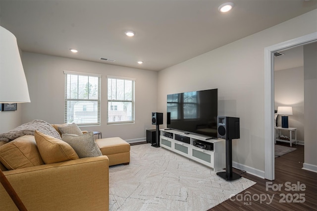 living area with baseboards, visible vents, wood finished floors, and recessed lighting