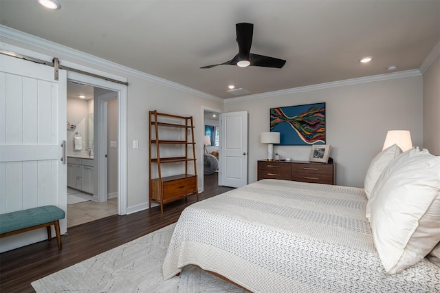 bedroom featuring crown molding, recessed lighting, a barn door, connected bathroom, and wood finished floors