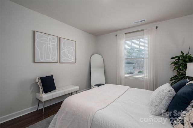 bedroom featuring baseboards, visible vents, and wood finished floors