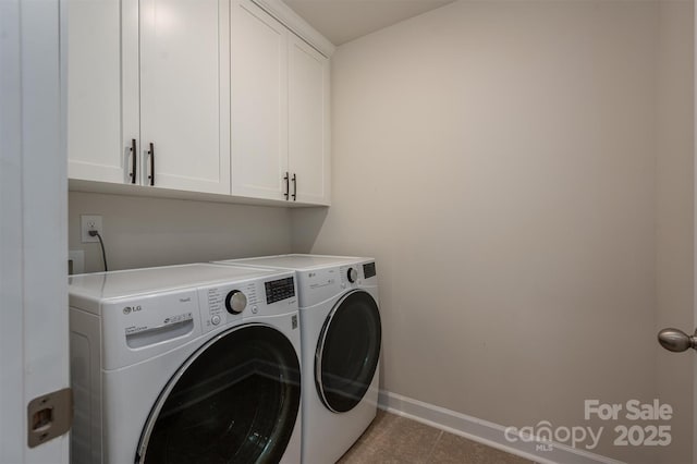 washroom with baseboards, light tile patterned floors, cabinet space, and washer and dryer