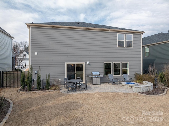 rear view of house with an outdoor fire pit, central air condition unit, fence, and a patio