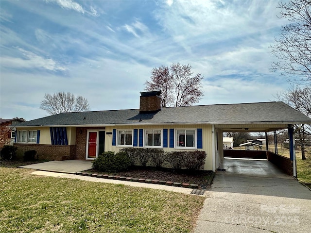 ranch-style house with an attached carport, brick siding, concrete driveway, a chimney, and a front yard