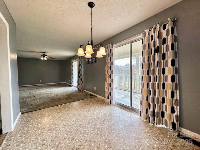 empty room with ceiling fan with notable chandelier, a textured ceiling, baseboards, and tile patterned floors