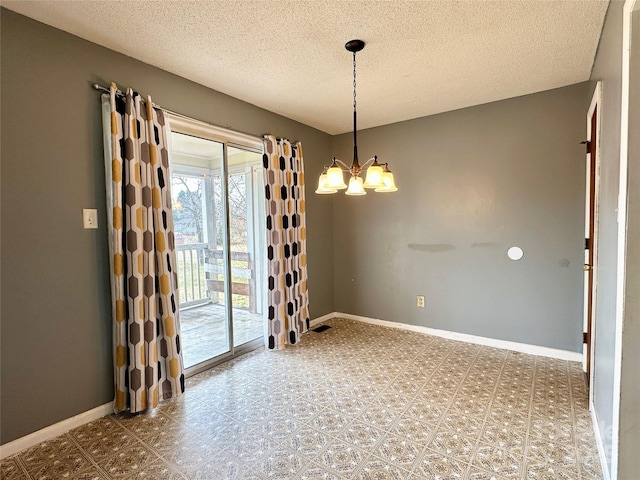 unfurnished room with an inviting chandelier, a textured ceiling, baseboards, and tile patterned floors