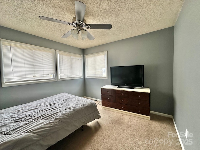 carpeted bedroom with a textured ceiling, a ceiling fan, and baseboards