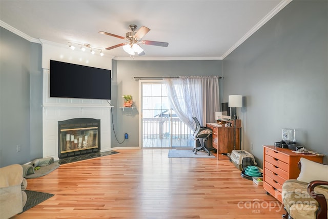 office area with a fireplace with flush hearth, crown molding, and wood finished floors