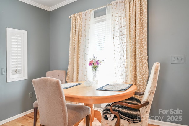 dining area featuring crown molding, wood finished floors, and baseboards