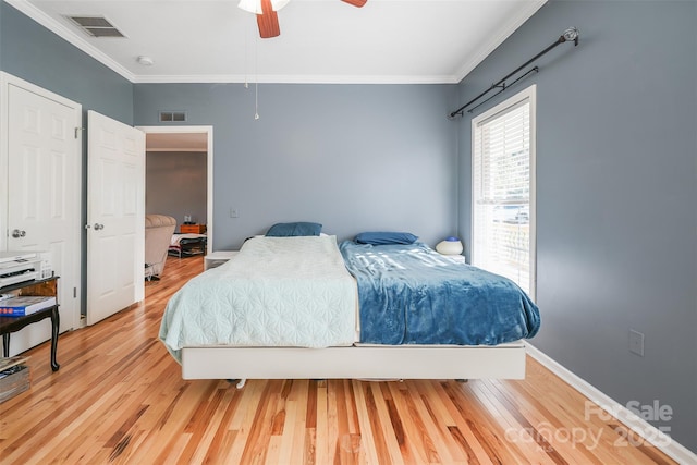 bedroom with ornamental molding, visible vents, and wood finished floors