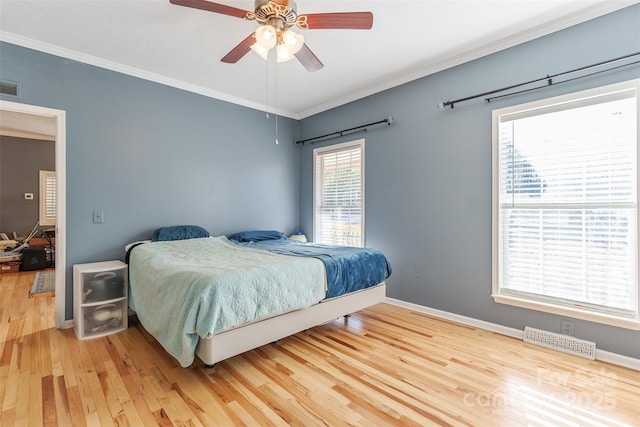 bedroom featuring ornamental molding, visible vents, and light wood finished floors