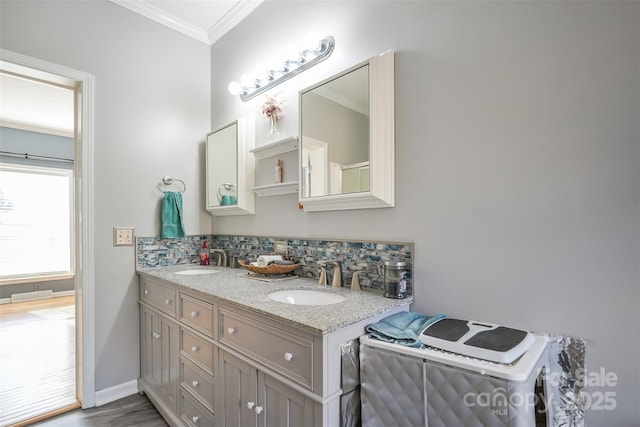 full bathroom with ornamental molding, baseboards, a sink, and decorative backsplash