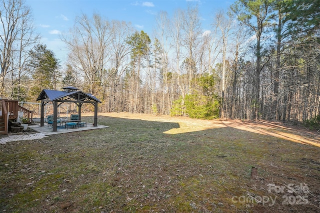 view of yard featuring a gazebo, a patio, and a view of trees