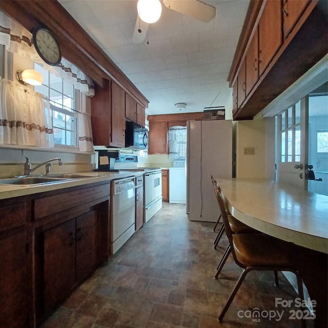 kitchen with washer / clothes dryer, electric range oven, freestanding refrigerator, black microwave, and dishwasher