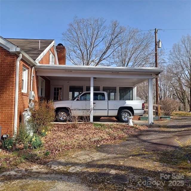 view of side of property with brick siding and a chimney