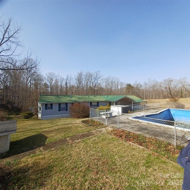 view of pool with a covered pool, fence, and a yard