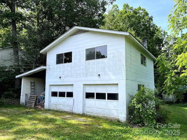 view of side of property featuring a garage, a yard, and driveway