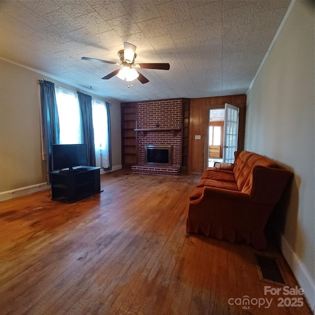 living room with a fireplace, visible vents, plenty of natural light, and hardwood / wood-style floors