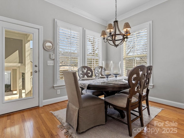 dining space featuring an inviting chandelier, baseboards, ornamental molding, and hardwood / wood-style floors