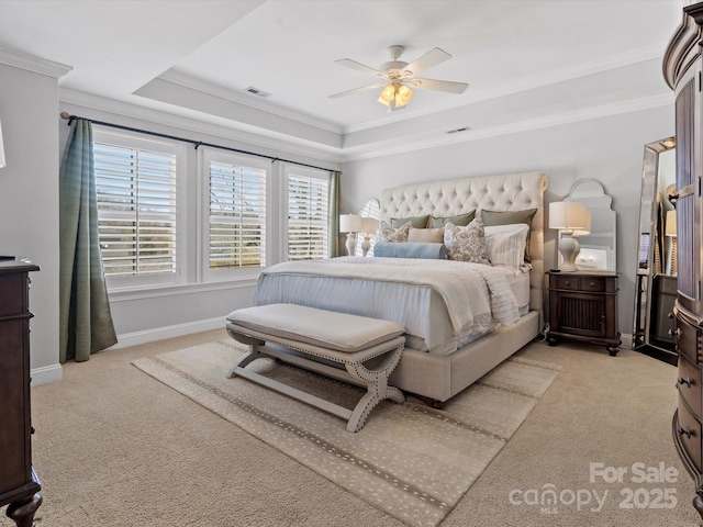 carpeted bedroom featuring visible vents, ornamental molding, and a raised ceiling