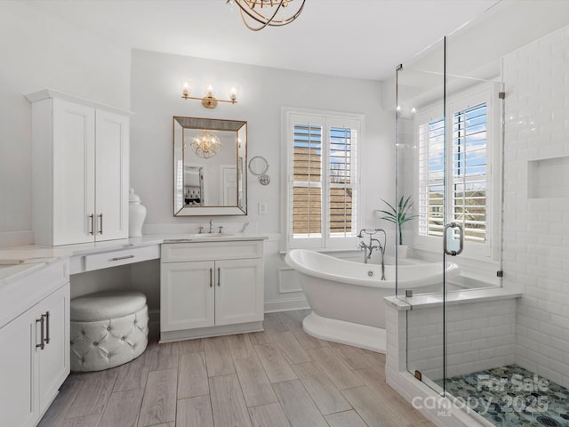 full bath featuring a stall shower, wood tiled floor, a soaking tub, and vanity