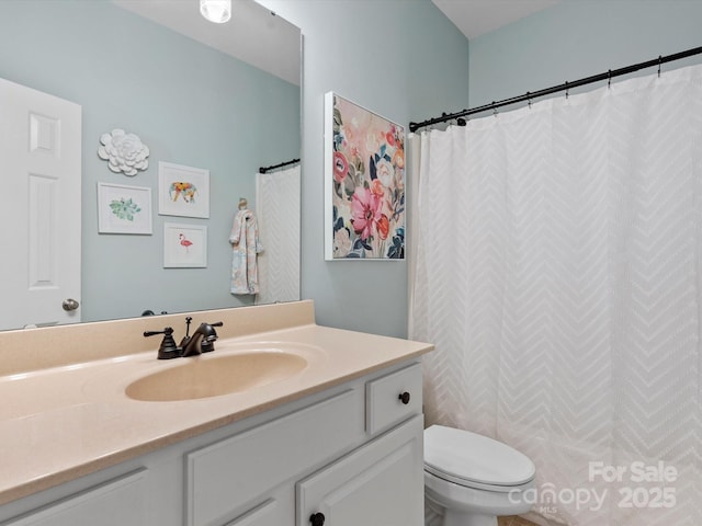 bathroom with a shower with shower curtain, vanity, and toilet