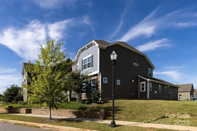 view of side of home with a lawn