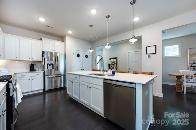 kitchen featuring stainless steel appliances, a sink, visible vents, and white cabinets