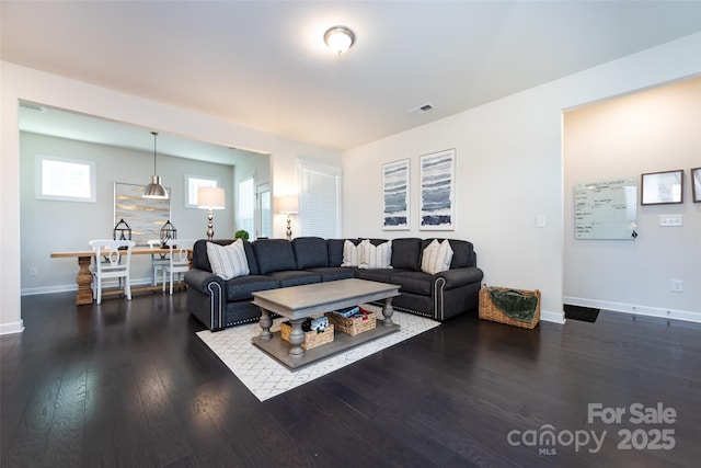 living room featuring dark wood-style floors, visible vents, and baseboards