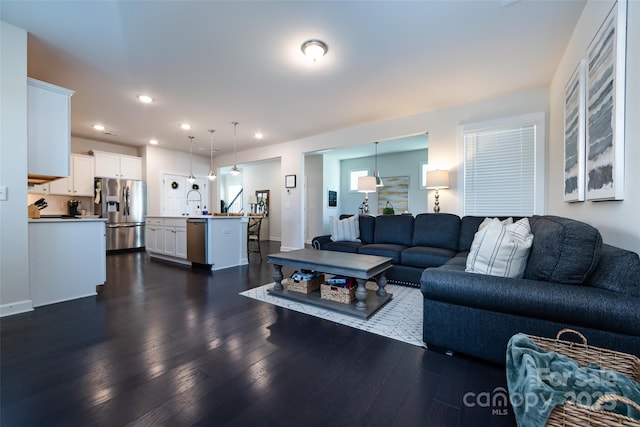 living room with dark wood-style floors, baseboards, and recessed lighting