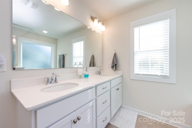 full bathroom featuring double vanity, a wealth of natural light, and a sink