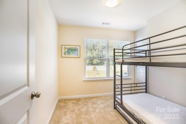 unfurnished bedroom with visible vents, light carpet, and baseboards