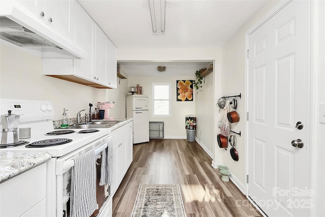 kitchen featuring under cabinet range hood, wood finished floors, a sink, light countertops, and white range with electric cooktop