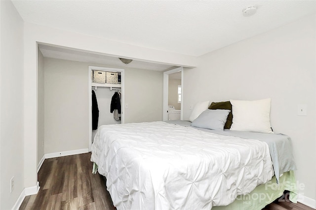 bedroom with washer / clothes dryer, wood finished floors, and baseboards