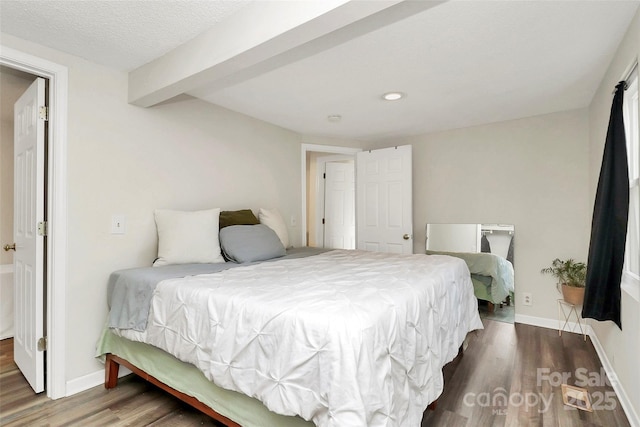 bedroom with a textured ceiling, baseboards, and wood finished floors