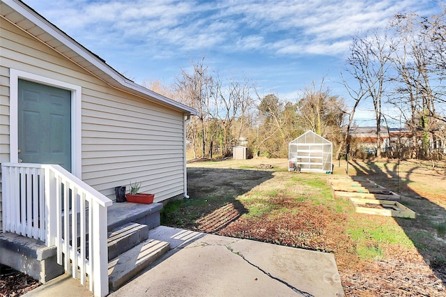 view of yard with an outbuilding and a greenhouse