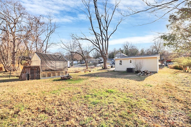 view of yard featuring central AC unit, an outdoor structure, and an exterior structure