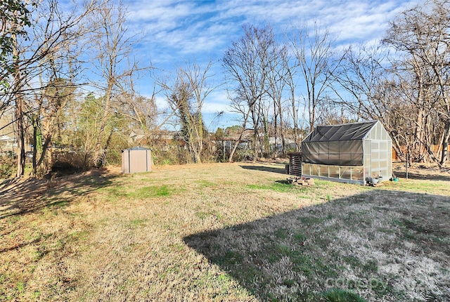 view of yard featuring an outbuilding and a greenhouse