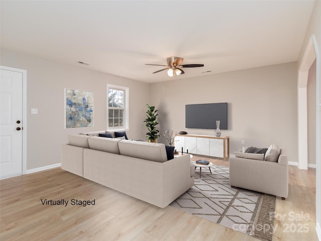 living room with ceiling fan, wood finished floors, visible vents, and baseboards