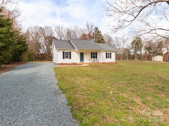 view of front of home with gravel driveway, a shingled roof, a porch, and a front lawn