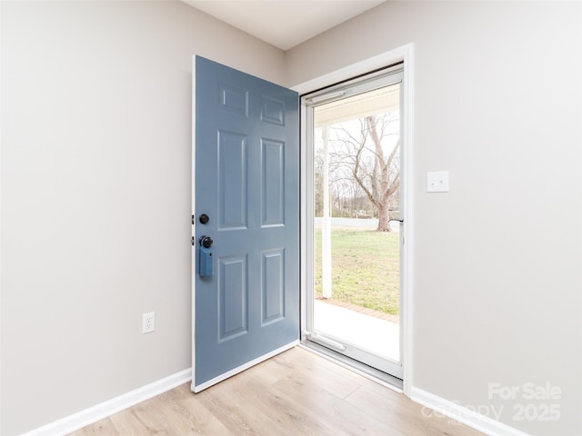 entryway featuring a wealth of natural light, baseboards, and light wood finished floors