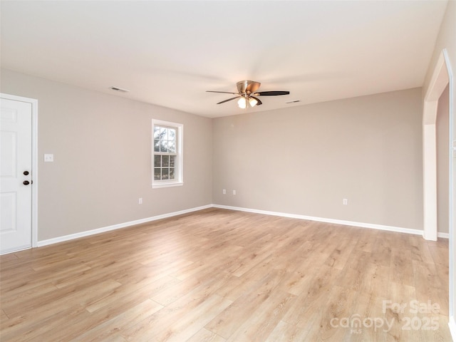 spare room featuring light wood-type flooring, visible vents, baseboards, and a ceiling fan