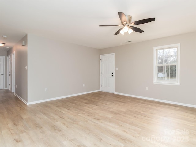 spare room featuring light wood-type flooring, baseboards, and a ceiling fan