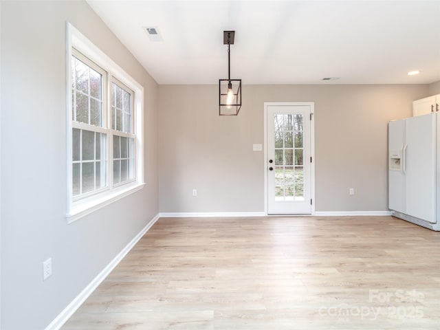 unfurnished dining area with light wood finished floors, recessed lighting, visible vents, and baseboards