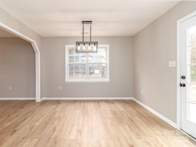 unfurnished dining area featuring light wood-style floors and baseboards