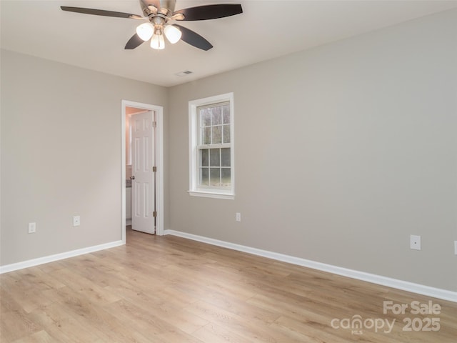 spare room with light wood-style floors, ceiling fan, visible vents, and baseboards