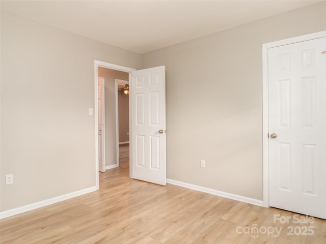 empty room with light wood-style flooring and baseboards