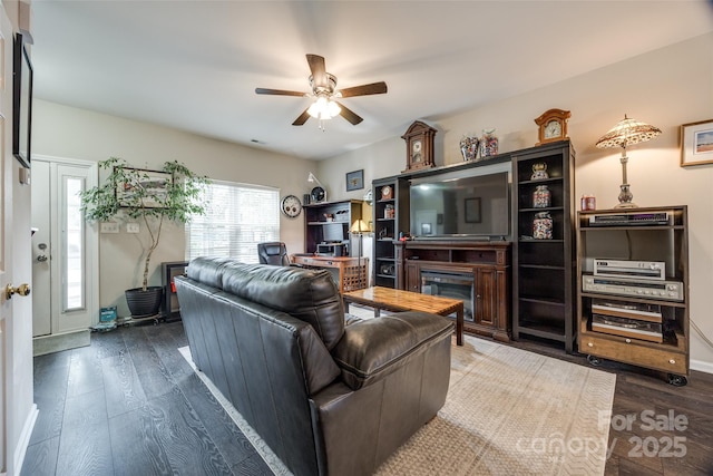 living area with ceiling fan, a fireplace, and hardwood / wood-style floors