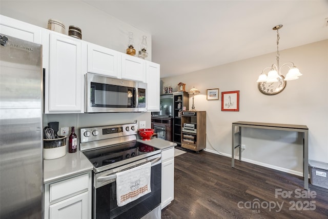 kitchen with pendant lighting, appliances with stainless steel finishes, dark wood-type flooring, and white cabinets